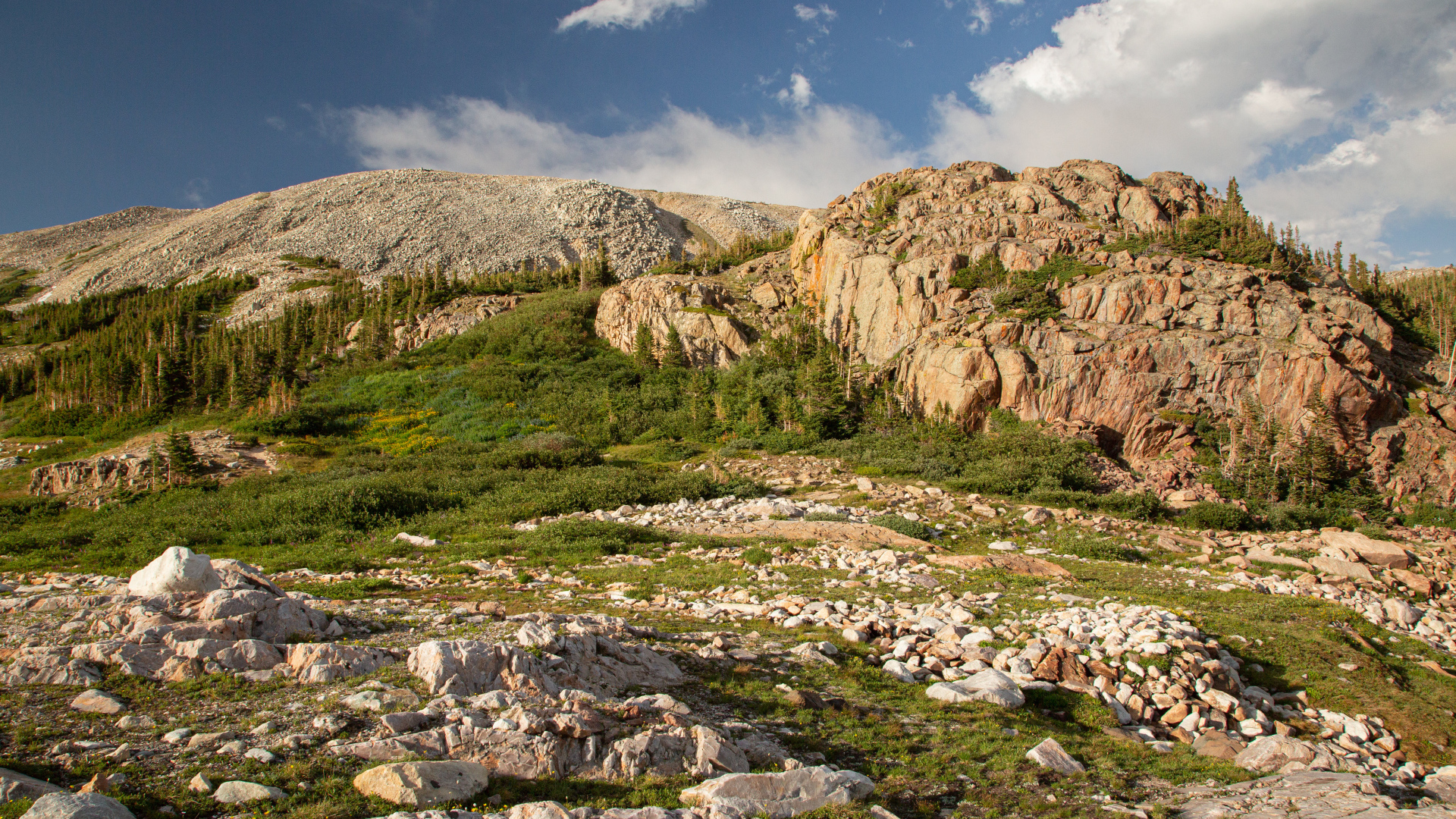 Высокие каменные горы под  голубым небом с белыми облаками