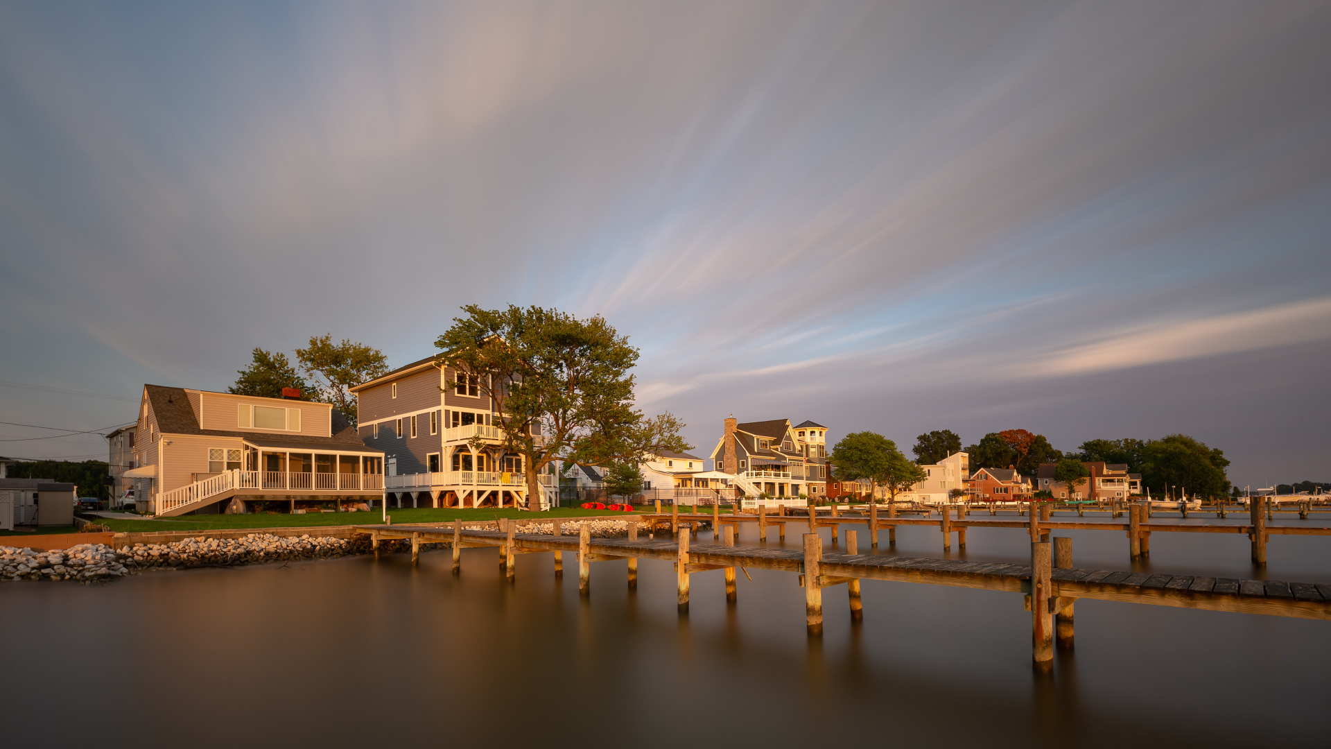 Мост у дома над тихой рекой под красивым небом