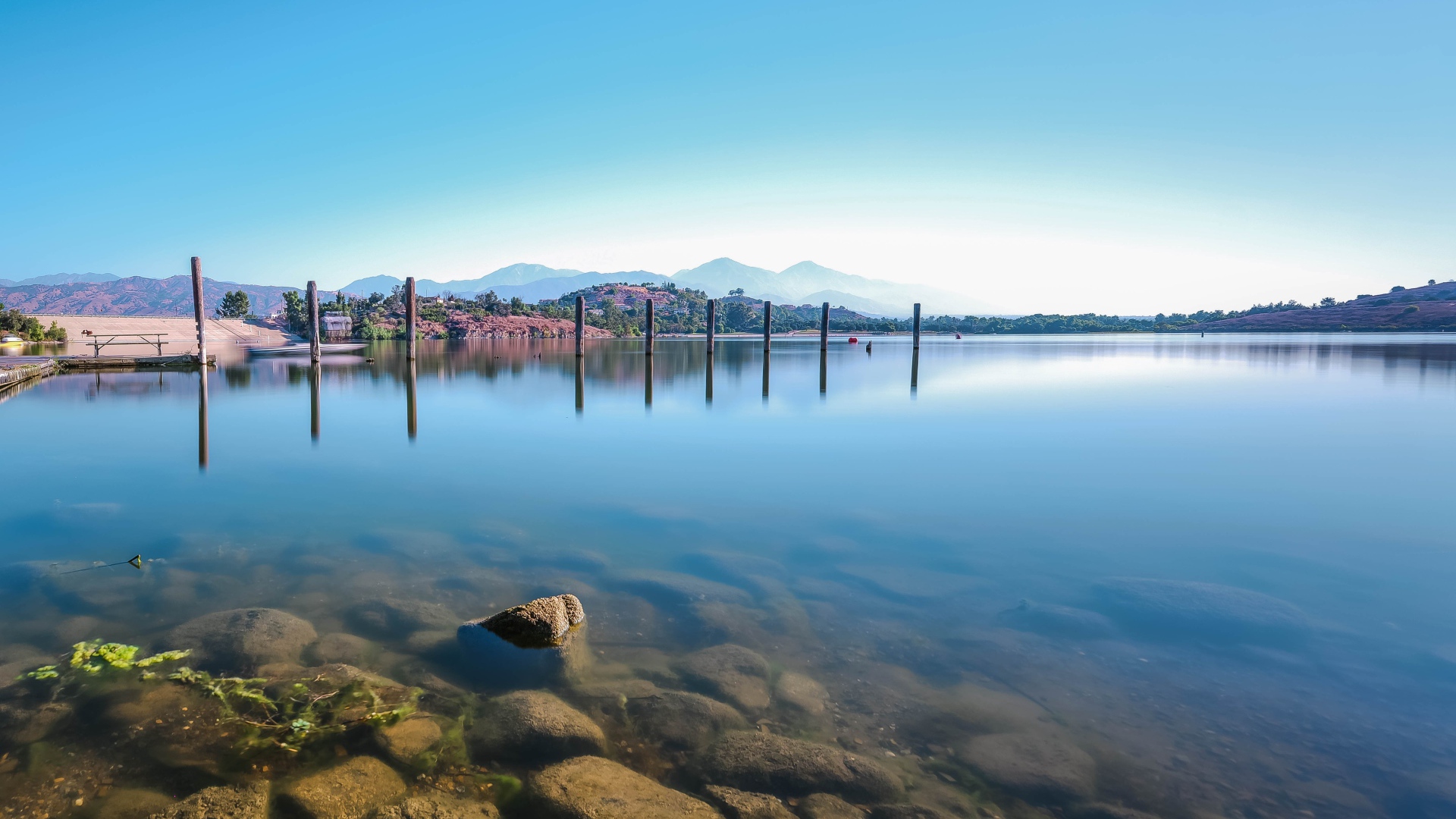 Камни в озере на фоне голубого неба