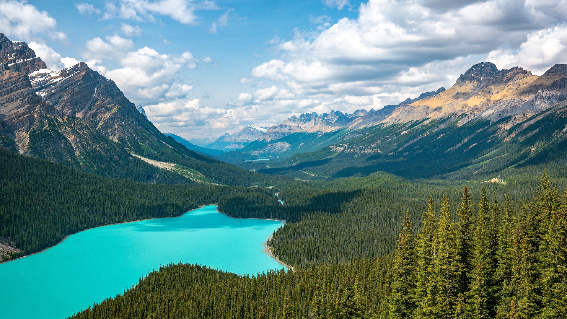 Вид на красивое голубое озеро и горную долину под солнечным небом с белыми облаками