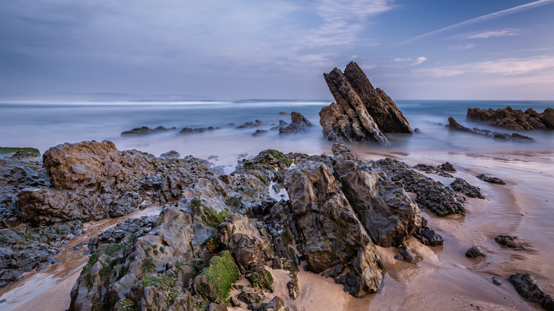 Туман над холодным утренним морем с камнями на берегу 