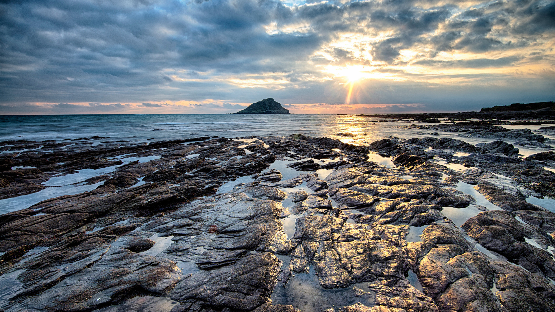 Каменный берег океана в лучах солнца