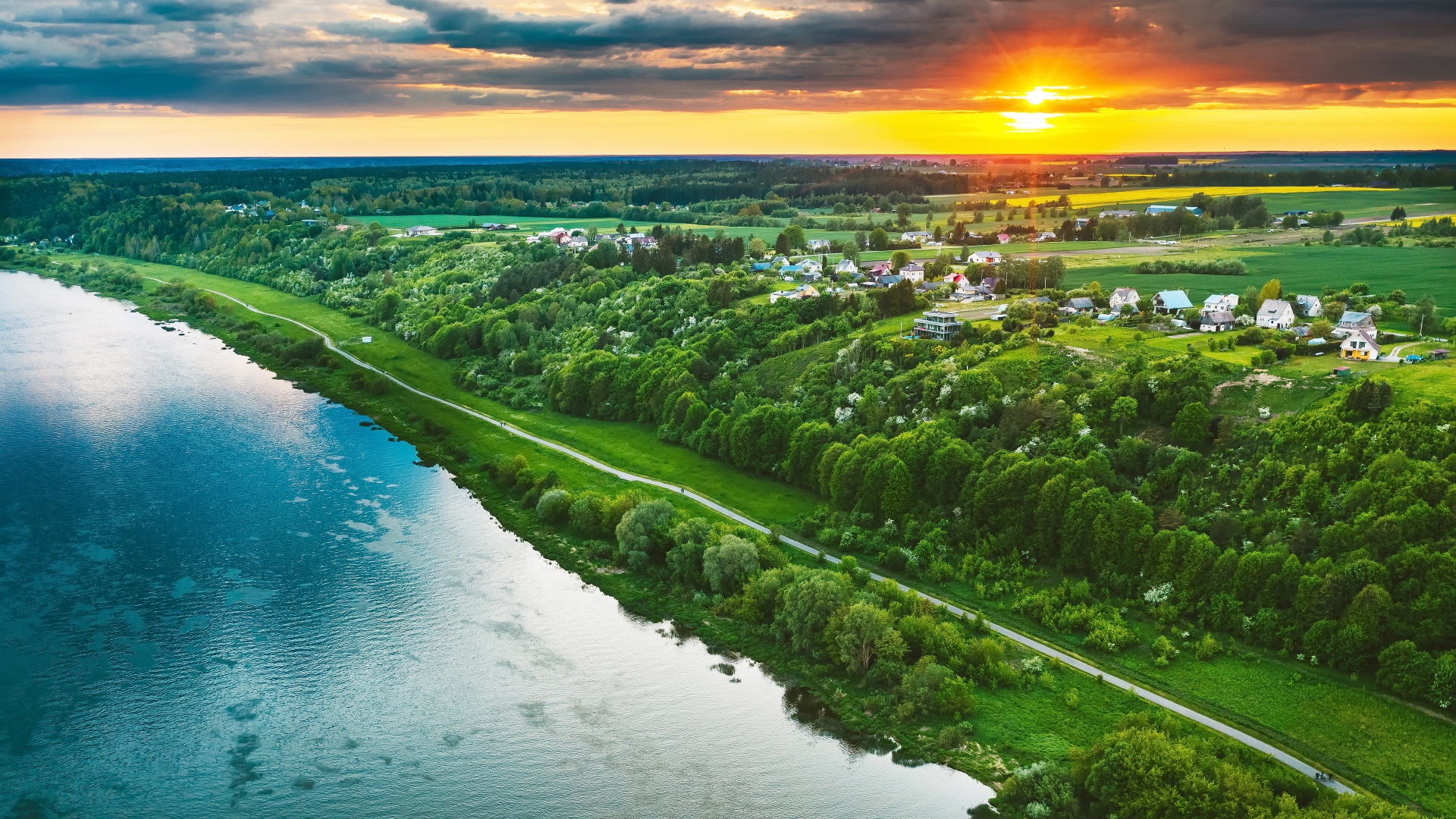 Закат солнца над городом у реки, вид с высоты 