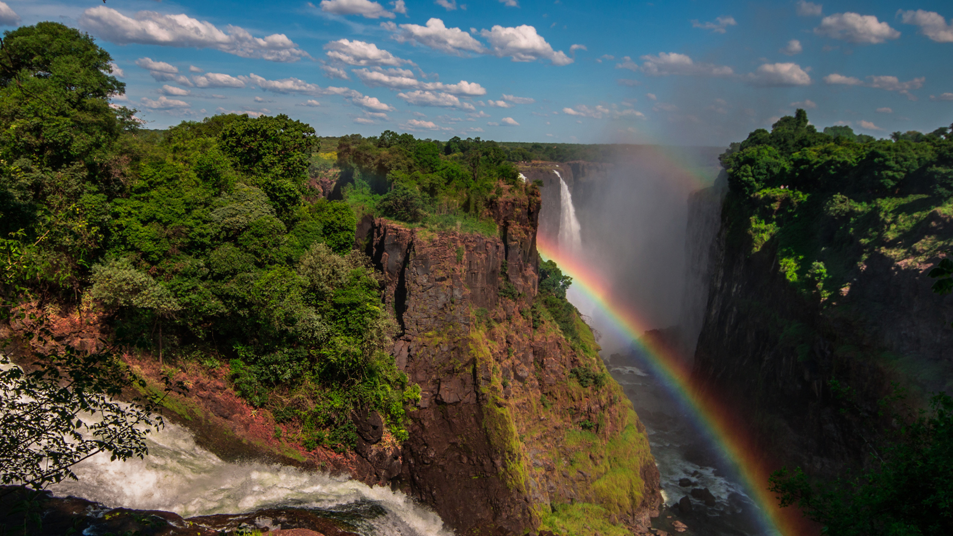 Радуга над водопадом на утесе 