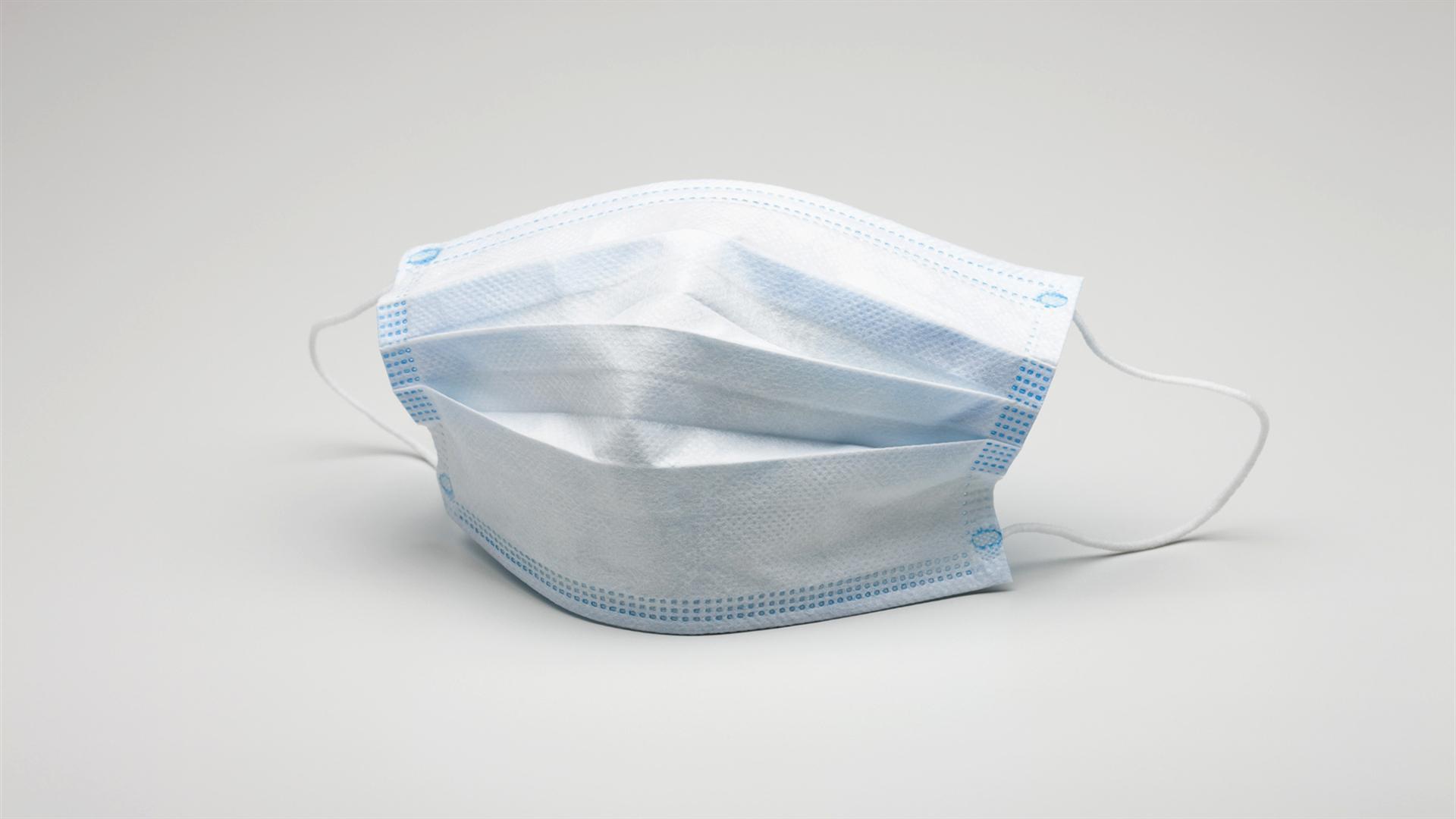 Медицинская маска защита от коронавирус covid-19 на сером фоне