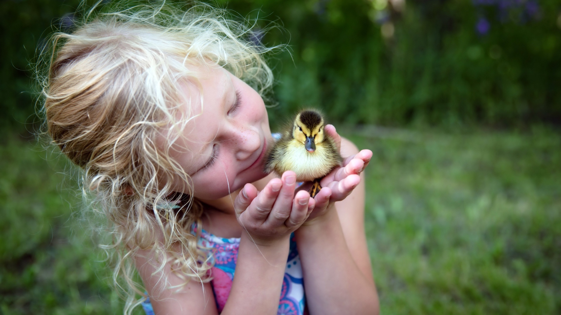Маленькая милая девочка с утенком в руке