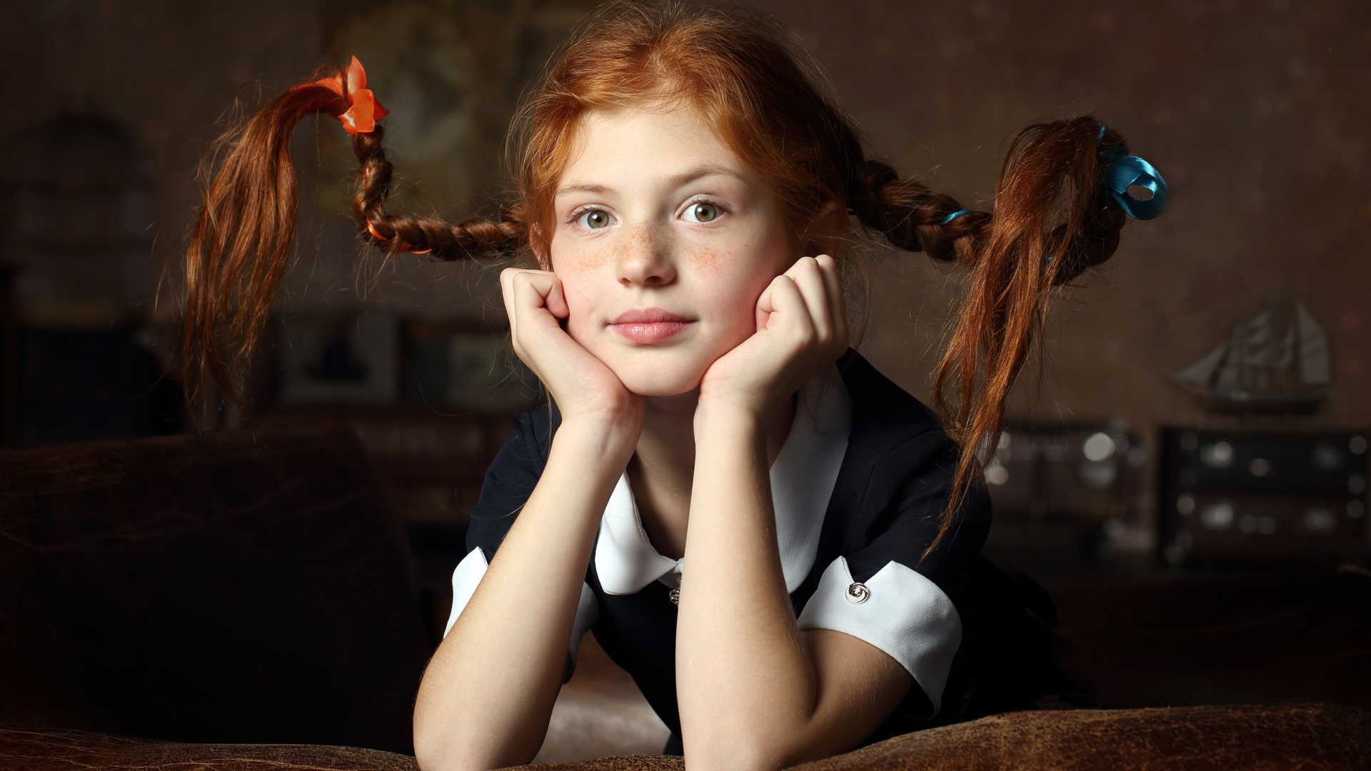 Маленькая смешная девочка с косами в школьной форме 