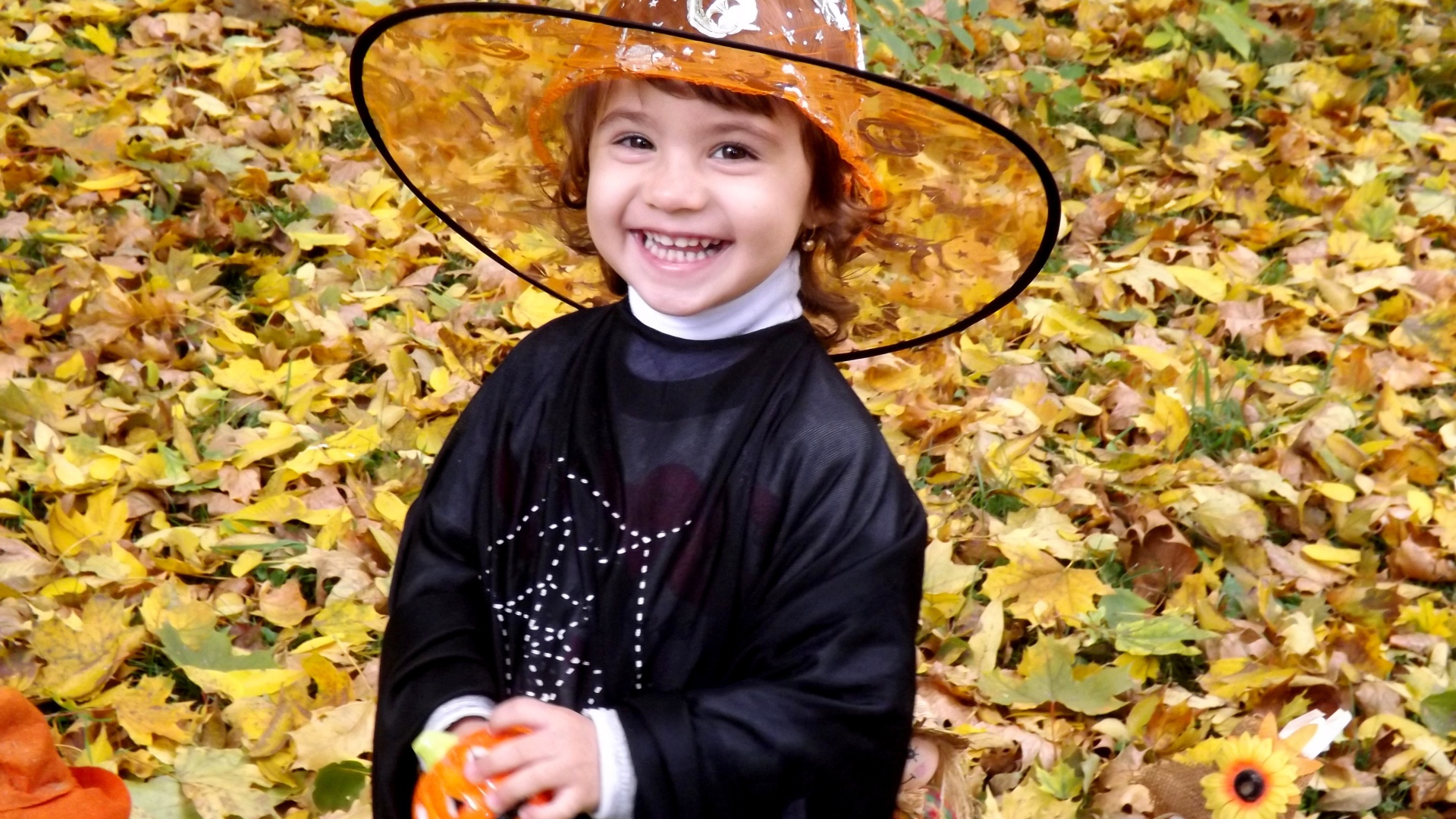 Улыбающаяся девочка в костюме ведьмы на Хэллоуин