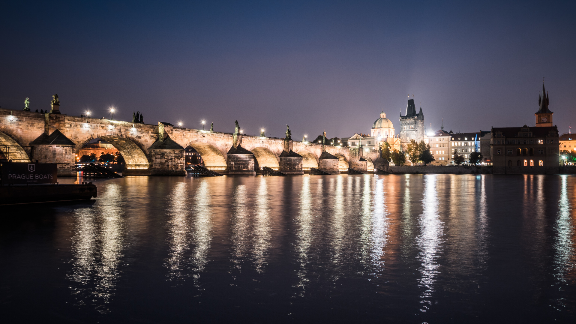 Charles Bridge is reflected in the water at night, Prague Czech Republic