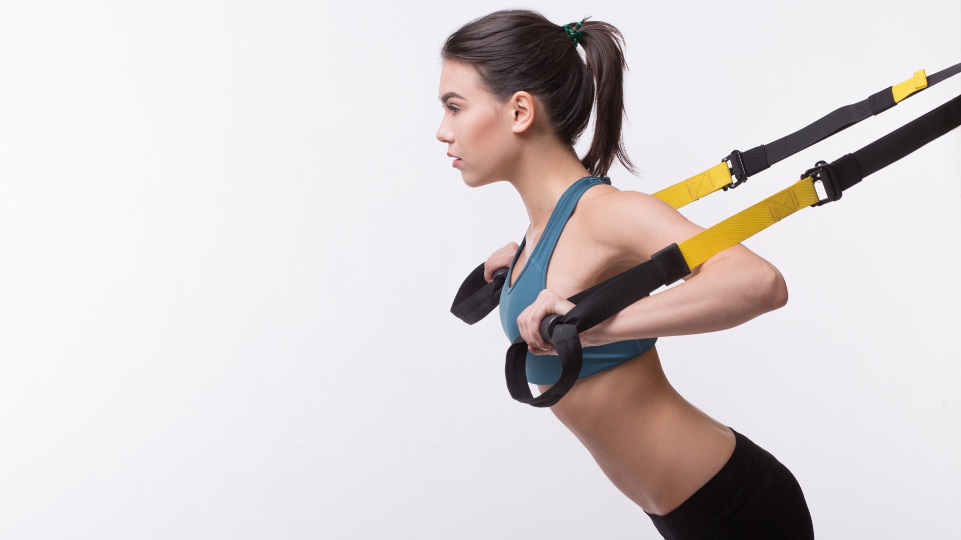 Спортивная девушка занимается в спортзале на белом фоне 