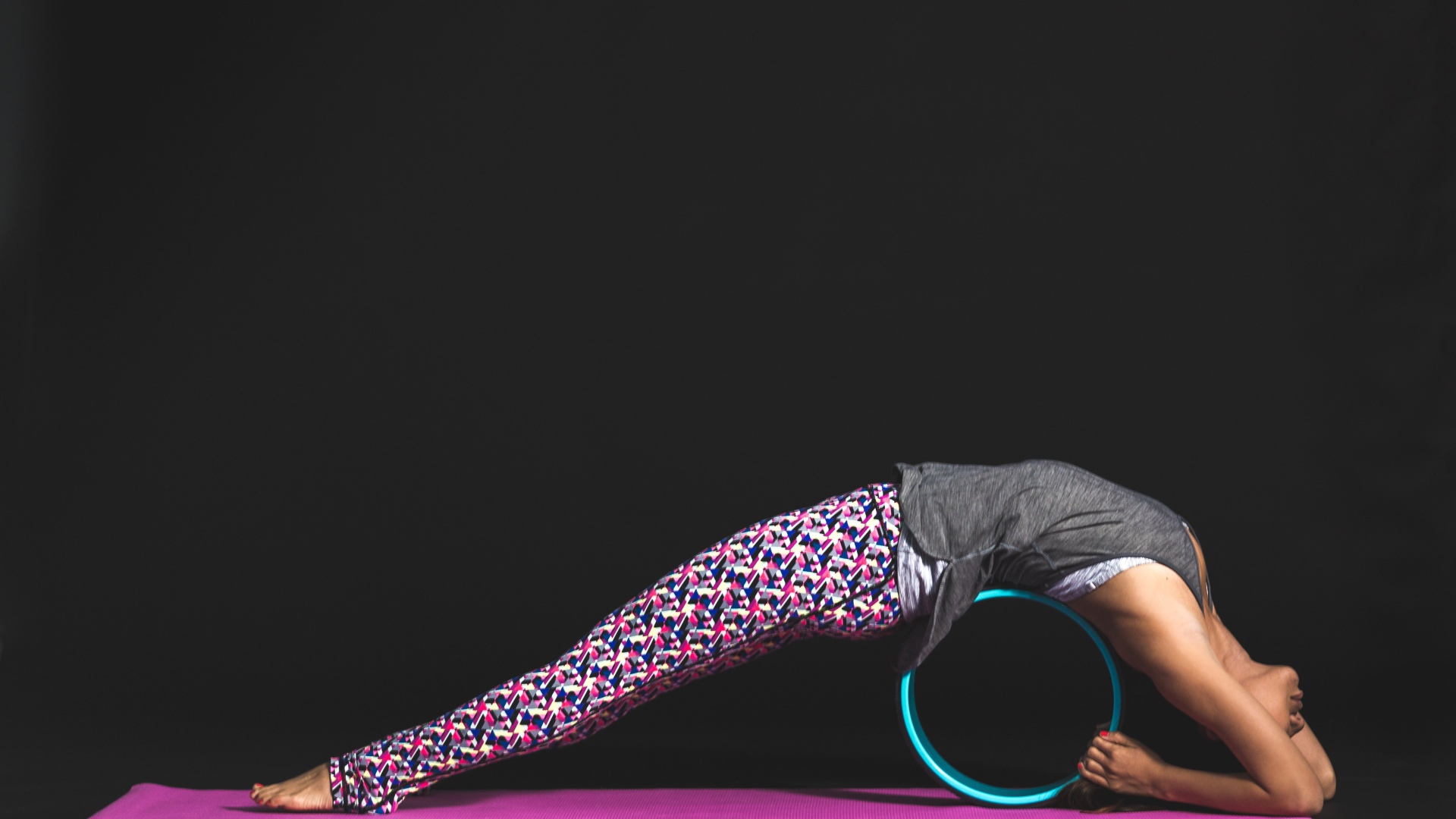 Девушка делает упражнения для спины на черном фоне