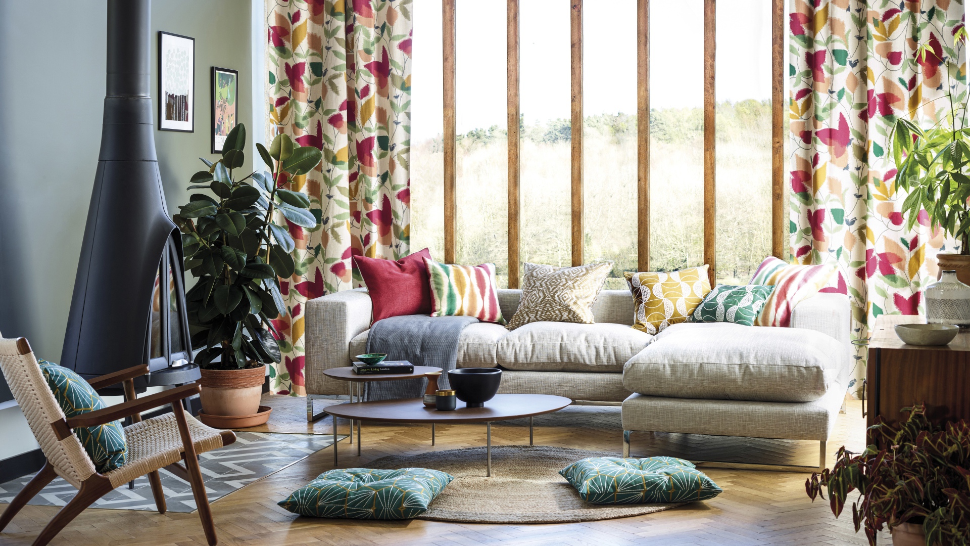 Серый мягкий диван стоит у большого окна в комнате