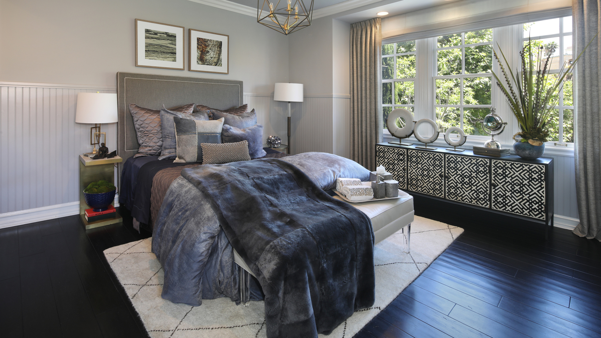 Большая кровать с мягким серым покрывалом в спальне 