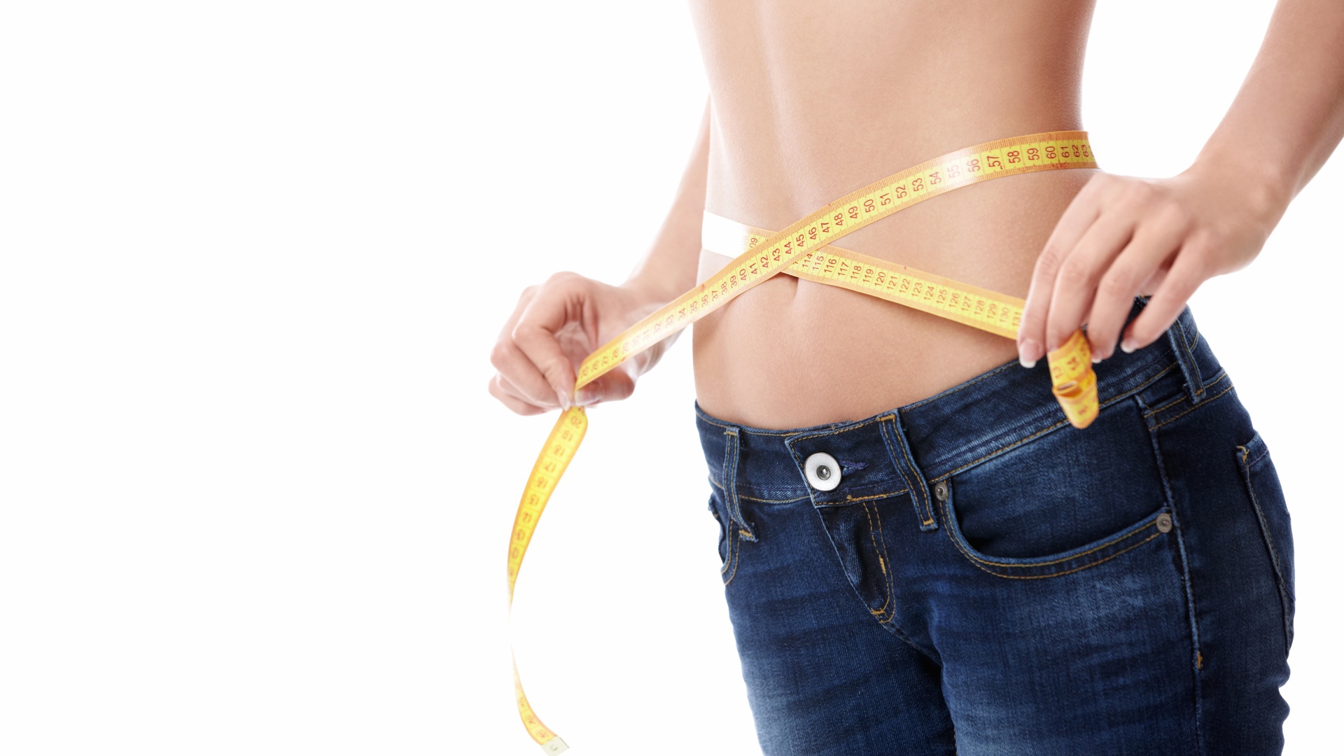 Стройная девушка меряет талию сантиметром 