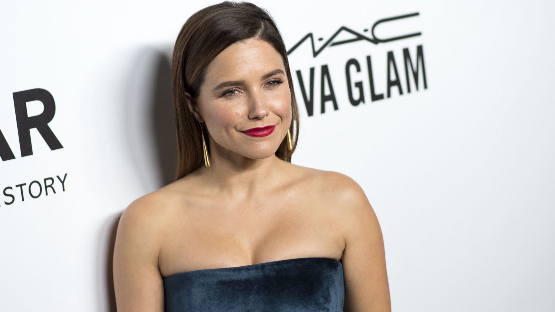 Улыбающаяся женщина, актриса София Буш у стены