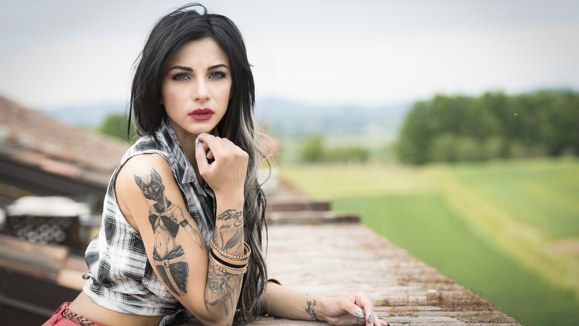 Молодая девушка брюнетка с татуировками на руках