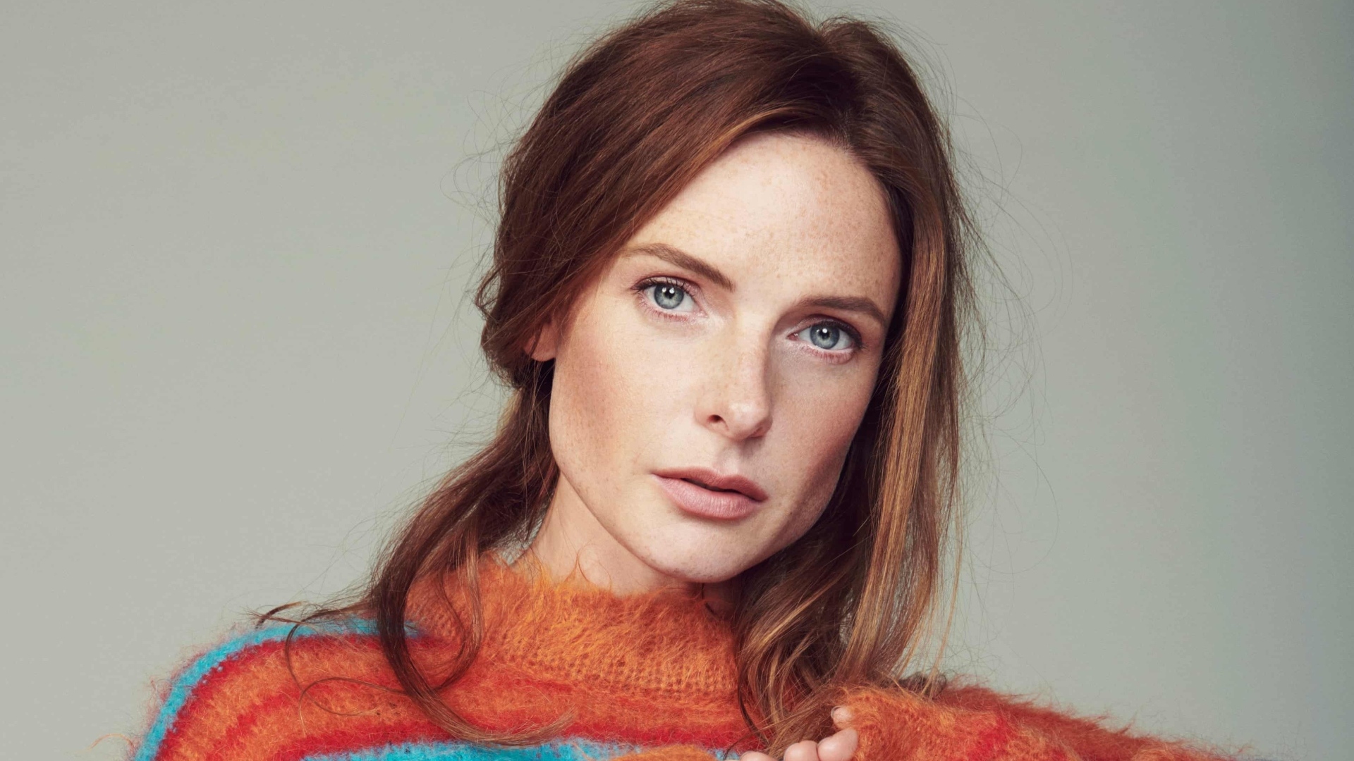 Рыжеволосая актриса Ребекка Фергюсон на сером фоне