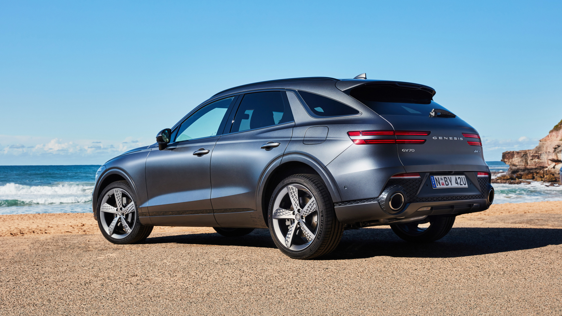 Серебристый автомобиль Genesis GV70 3.5T AWD 2021 года вид сзади 