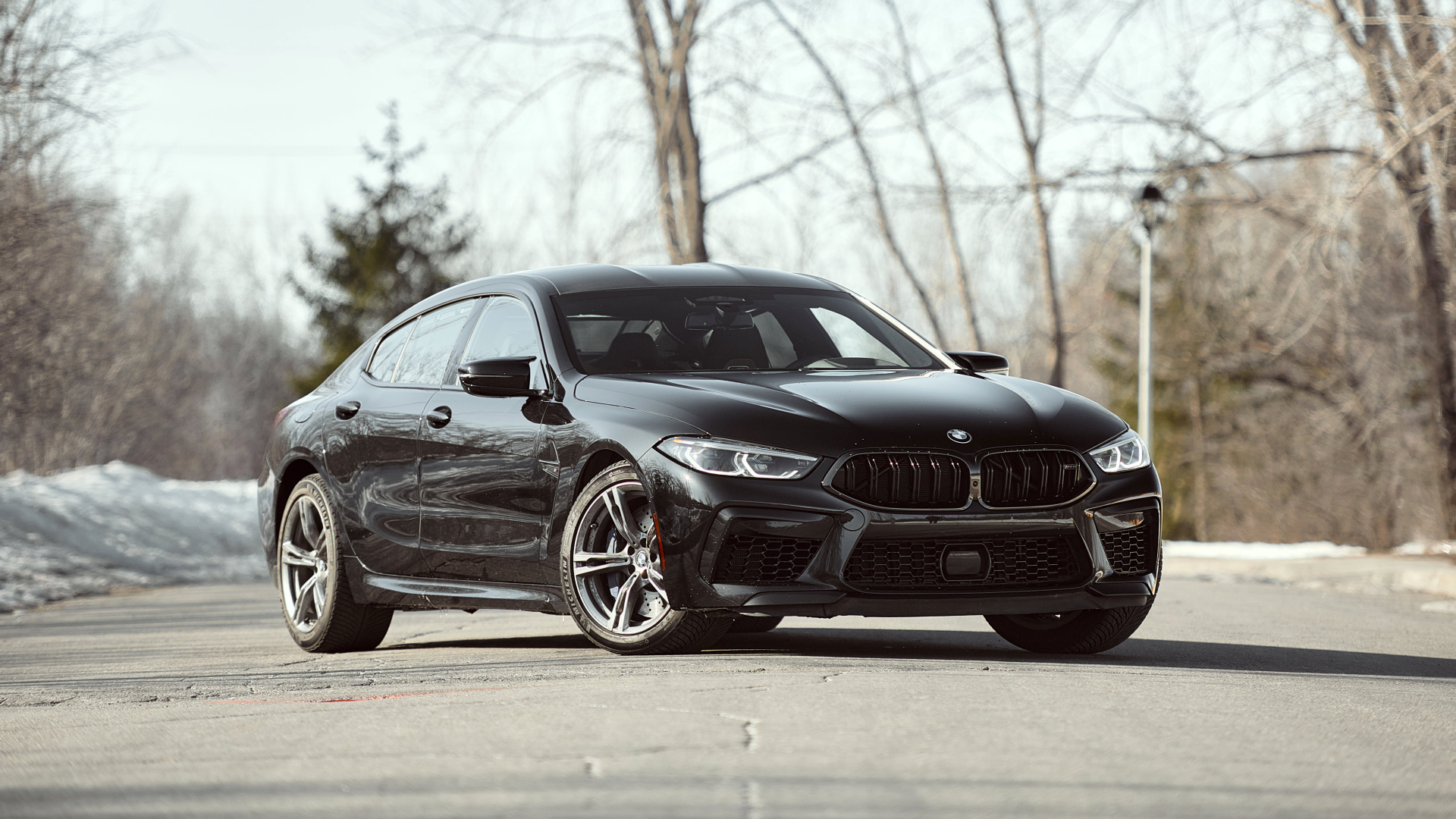 Черный автомобиль BMW M8 в лучах солнца