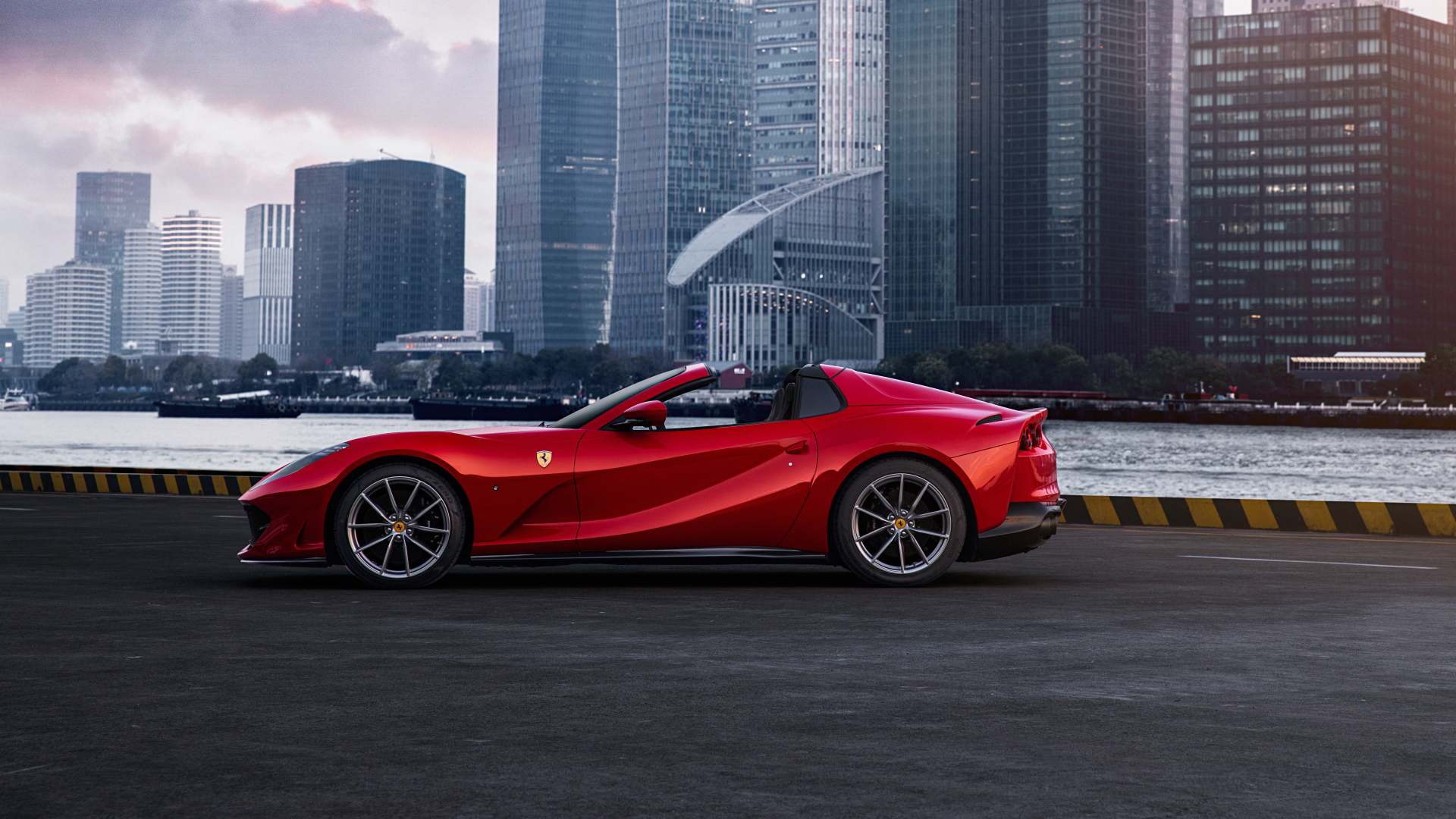 Красный автомобиль  Ferrari 812 GTS на фоне города