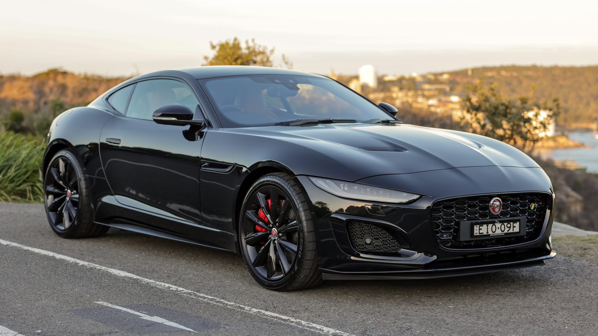 Дорогой черный автомобиль Jaguar F-Type R на дороге