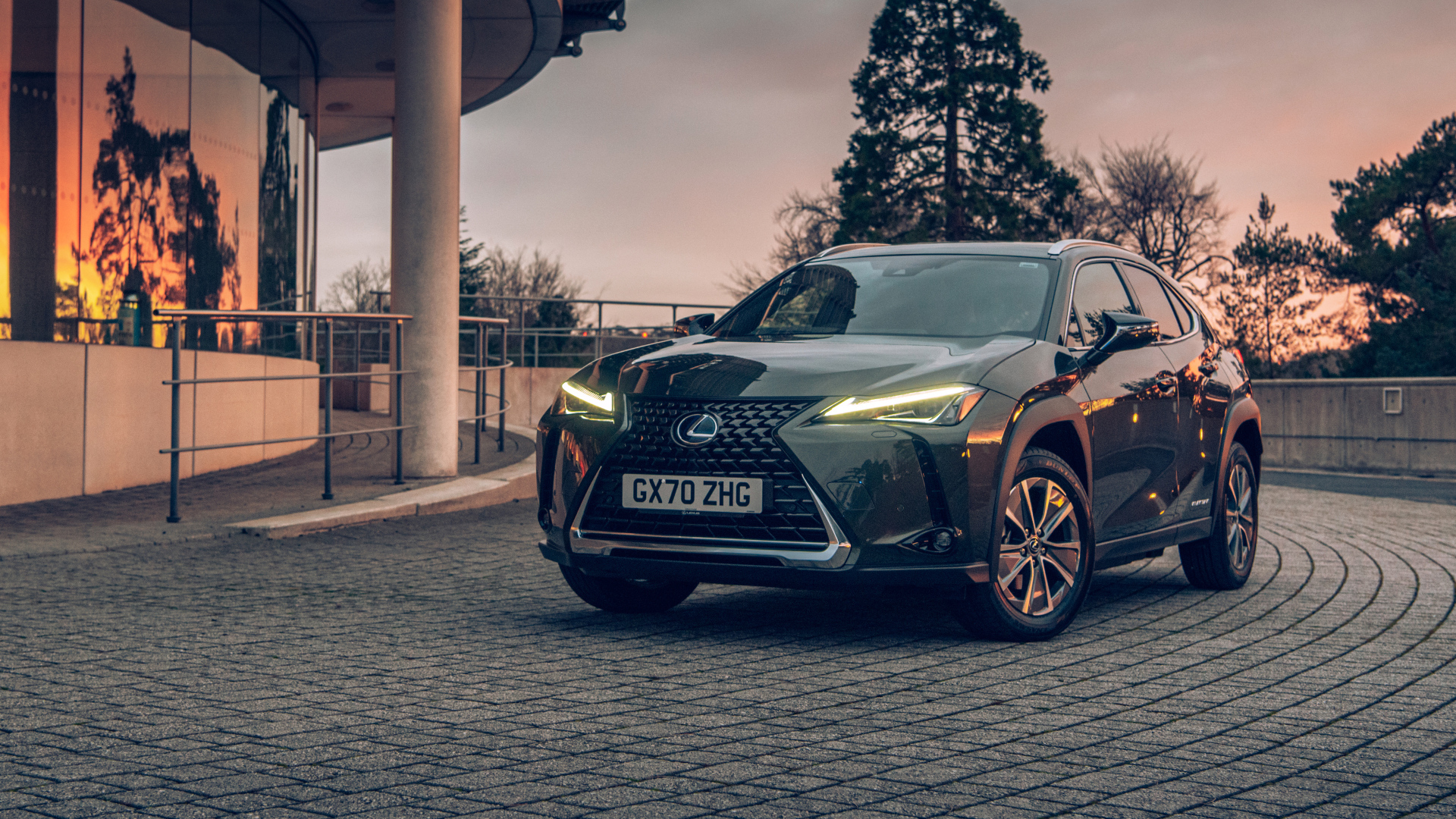 Автомобиль Lexus UX 300e 2021 года с включенными фарами