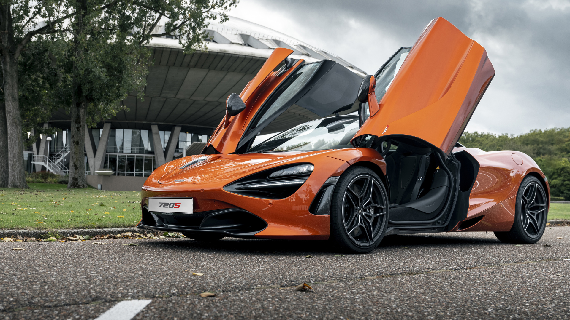 Оранжевый автомобиль McLaren 720S 2021 года с открытыми дверями