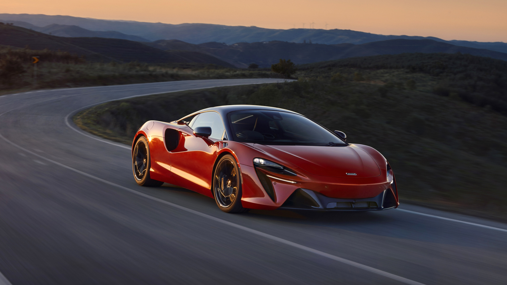 Красный автомобиль McLaren Artura, 2022 года на трассе