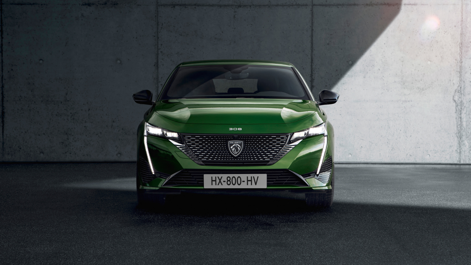 Автомобиль Peugeot 308, 2021 года вид спереди на фоне стены