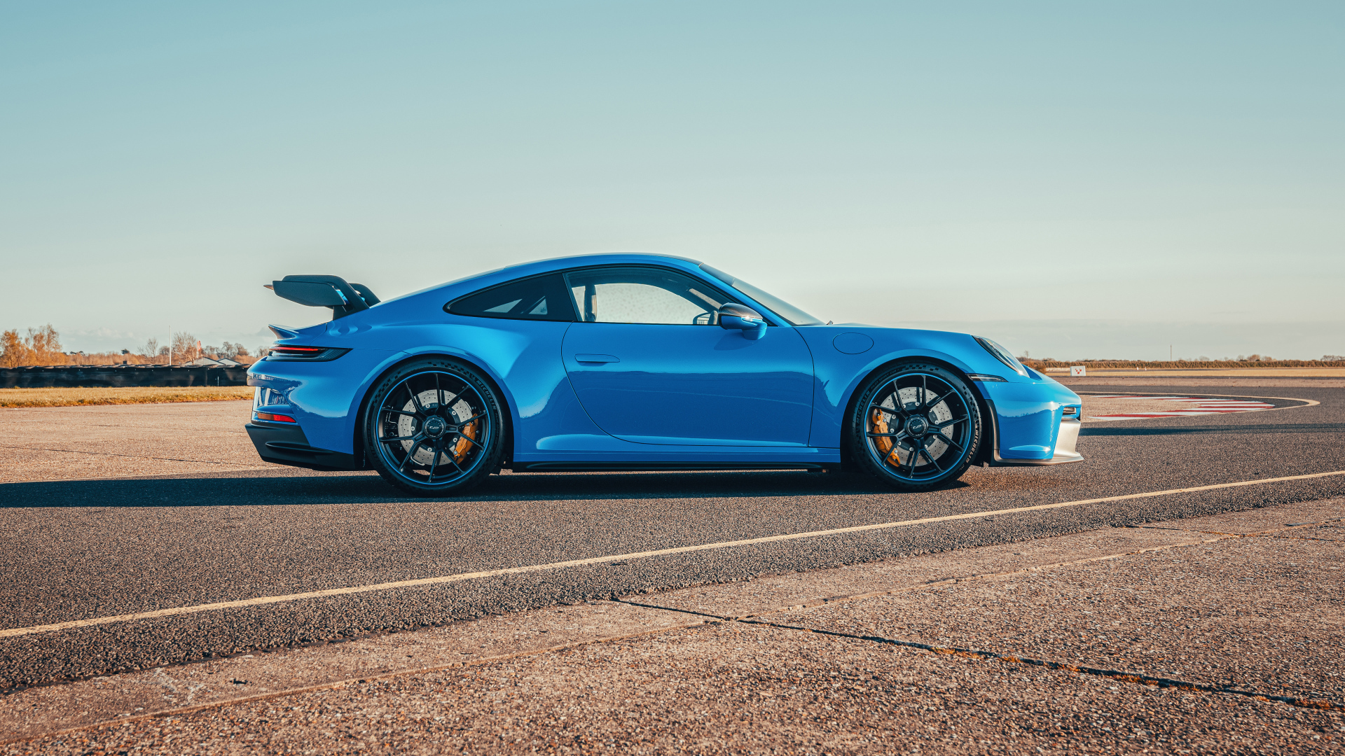 Голубой автомобиль Porsche 911 GT3 PDK 2021 года вид сбоку