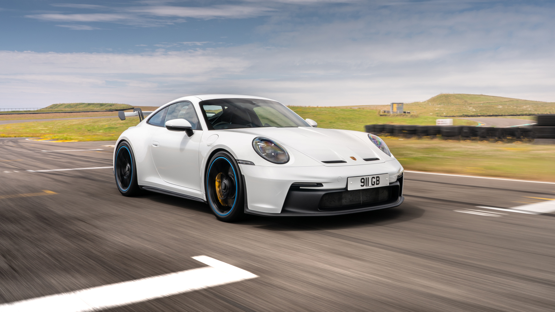 Белый автомобиль Porsche 911 GT3 PDK 2021  года на трассе
