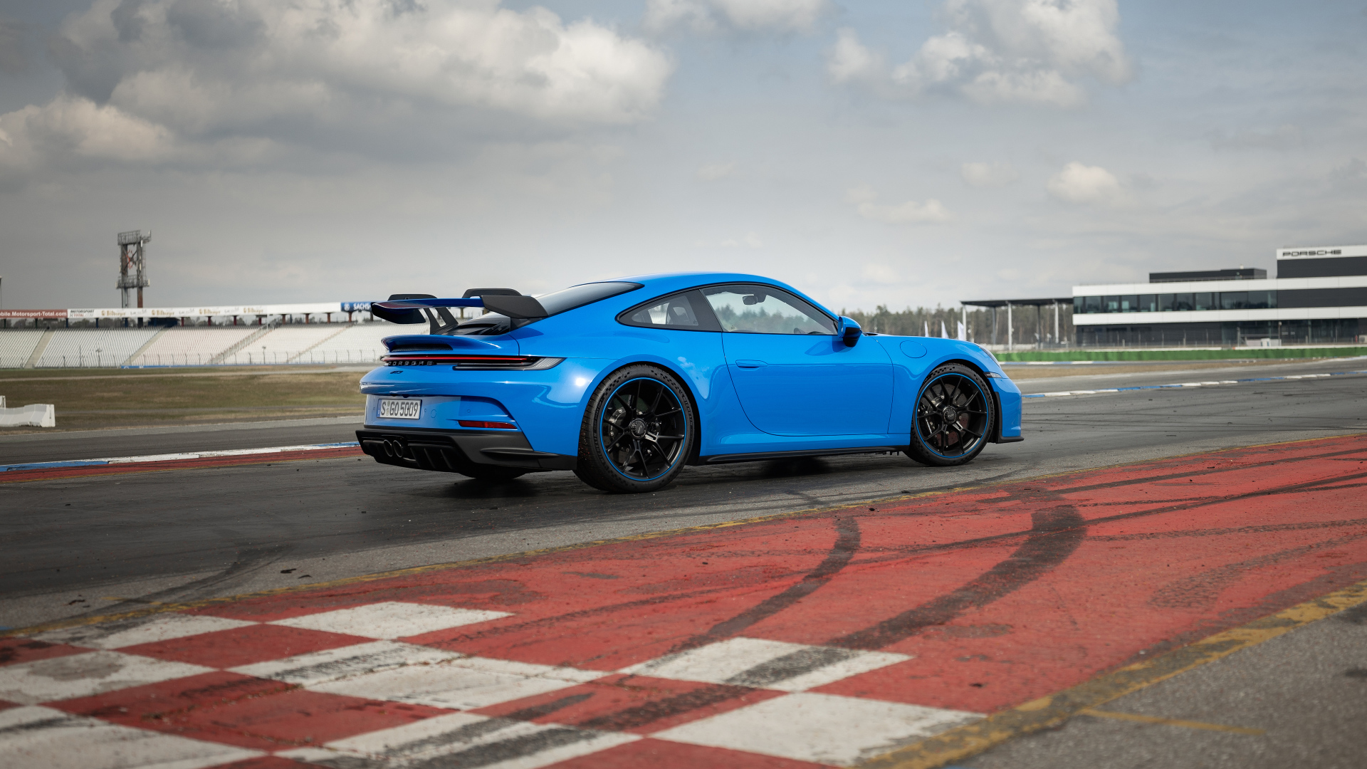 Голубой автомобиль  Porsche 911 GT3 2021 года на трассе