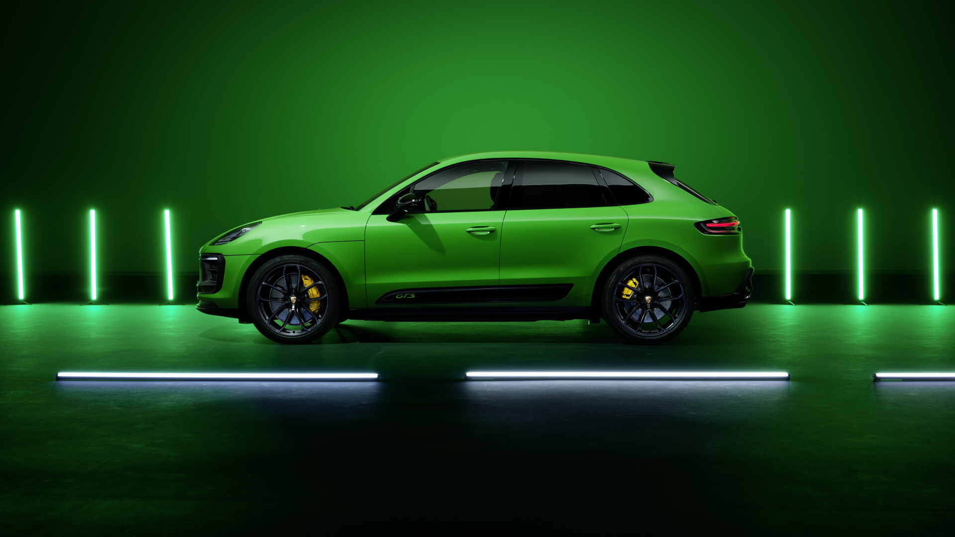 Зеленый автомобиль Porsche Macan GTS Sport Package 2021 года на фоне стены 