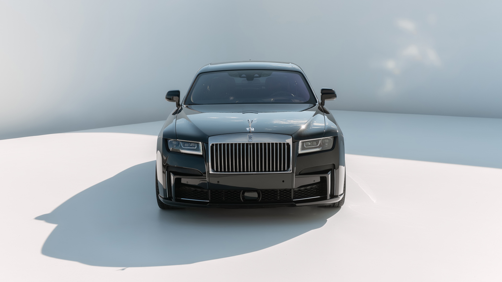 Автомобиль Rolls-Royce Ghost 2021 года на сером фоне