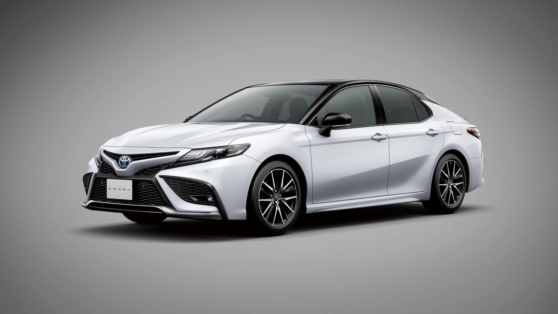 Автомобиль Toyota Camry 2021 года на сером фоне