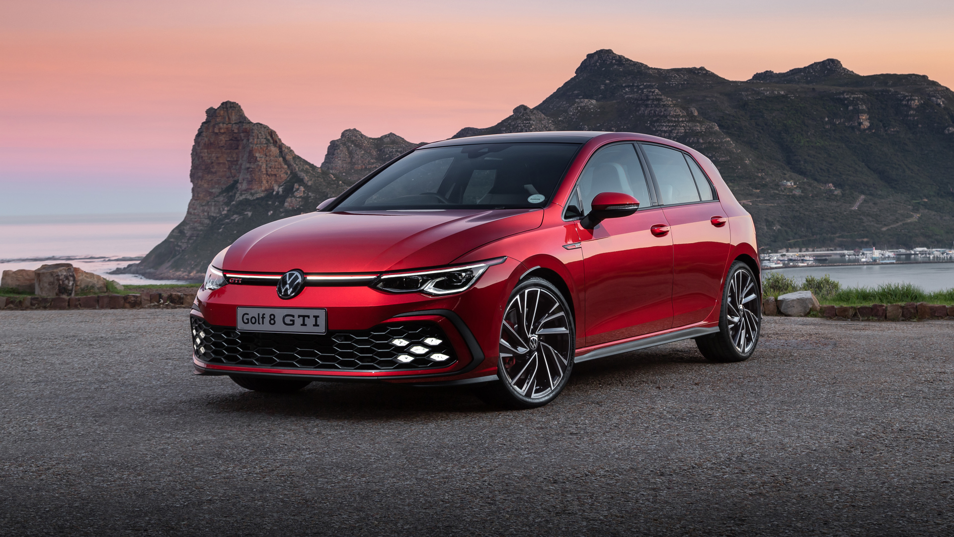 Красный Volkswagen Golf GTI 2021 года на фоне гор