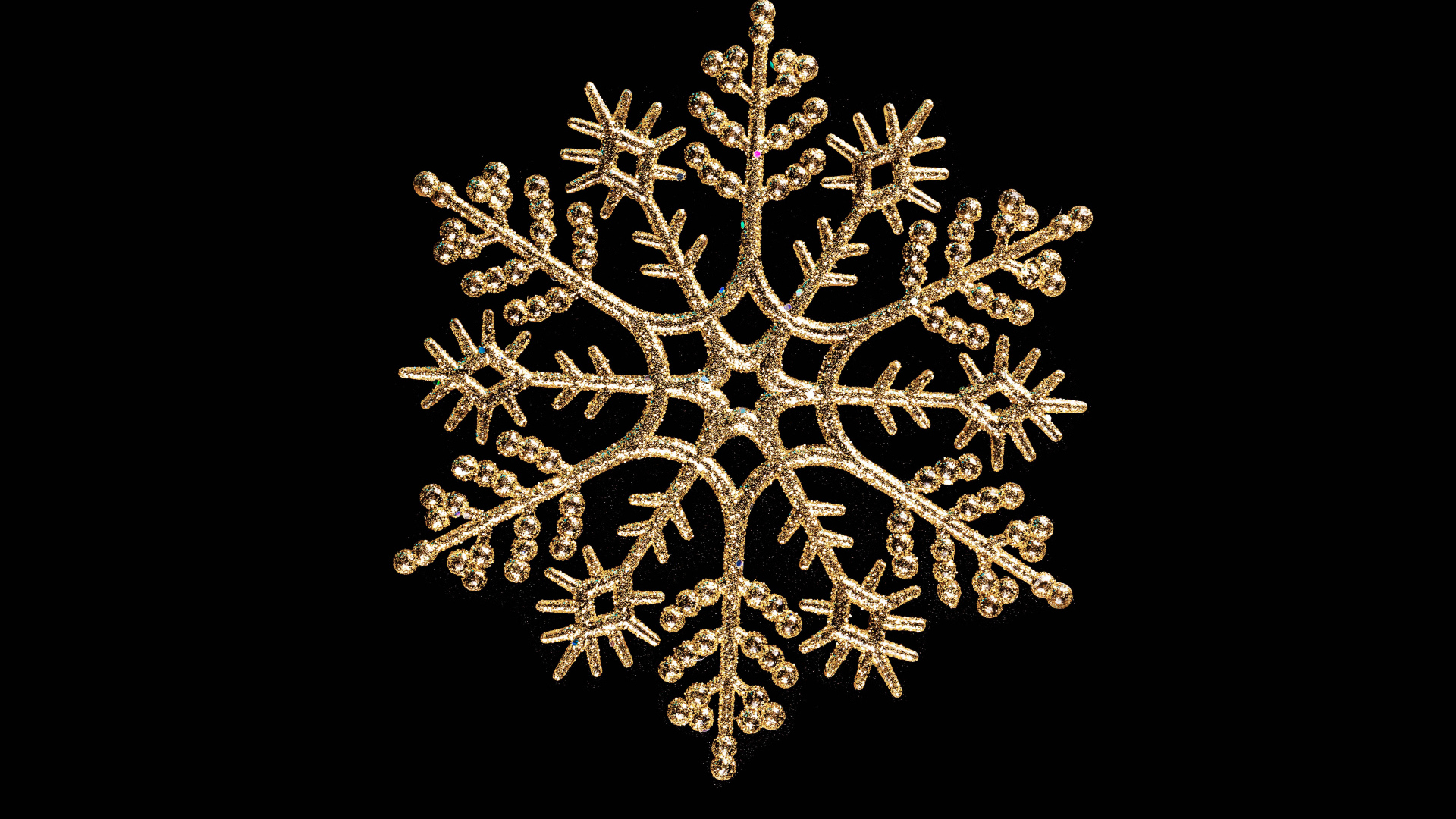 Красивая золотистая снежинка на черном фоне