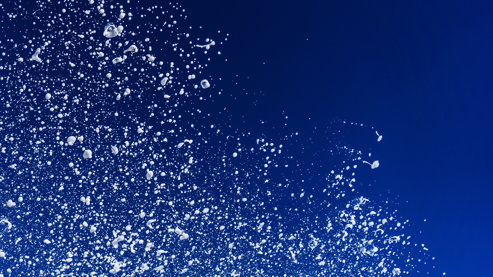 Белые брызги воды на синем фоне 