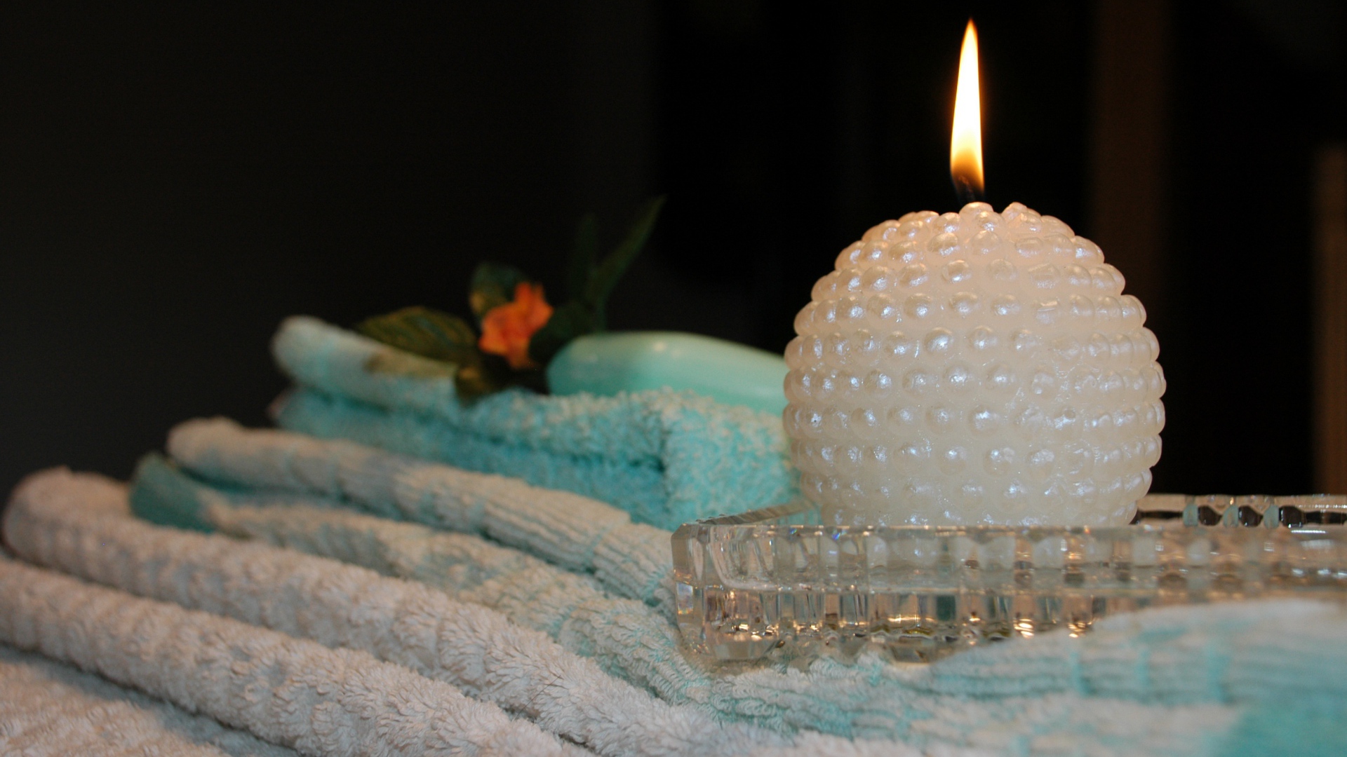 Красивая зажженная свеча с полотенцами