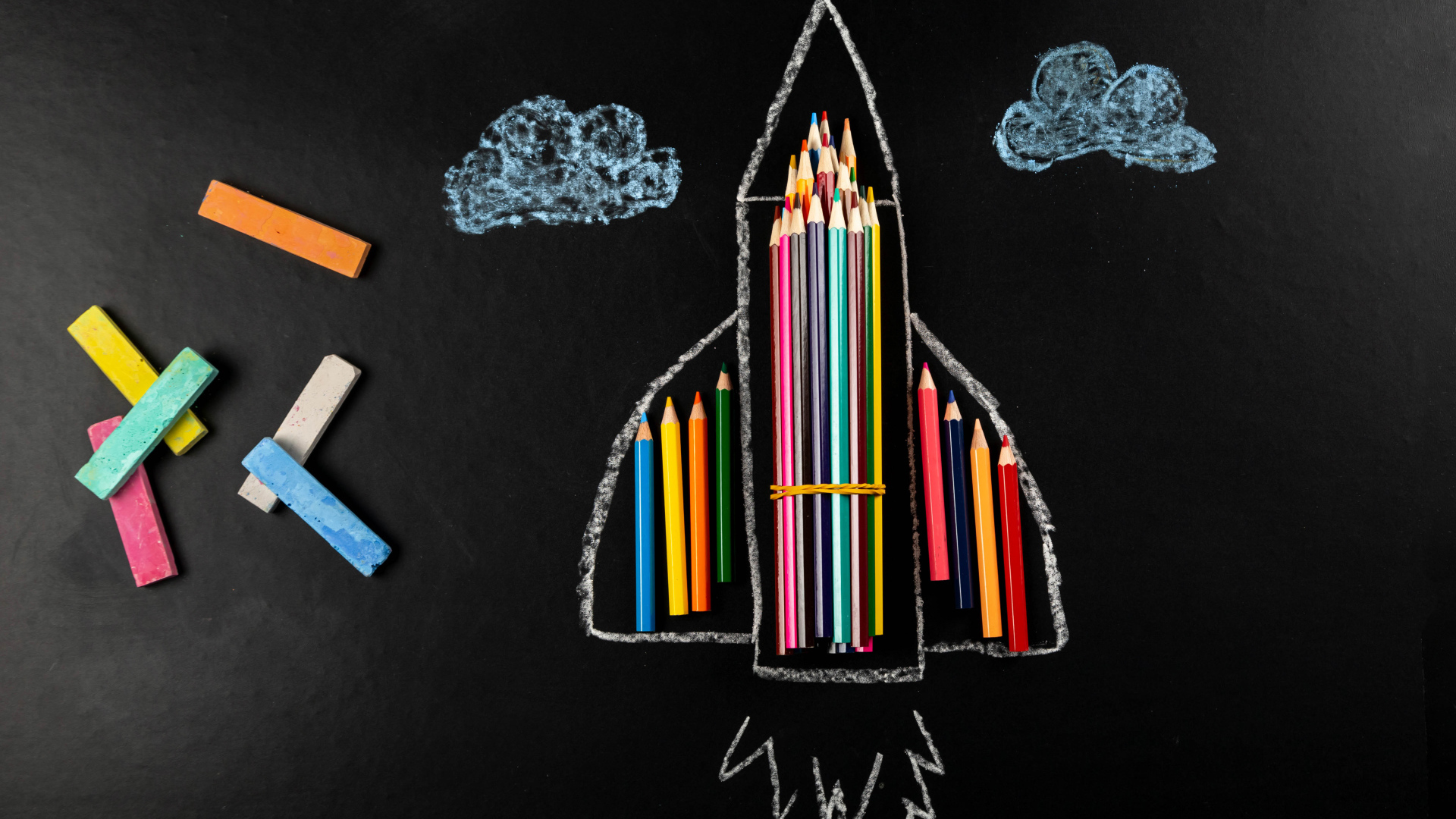 Нарисованная ракета с мелом и карандашами 