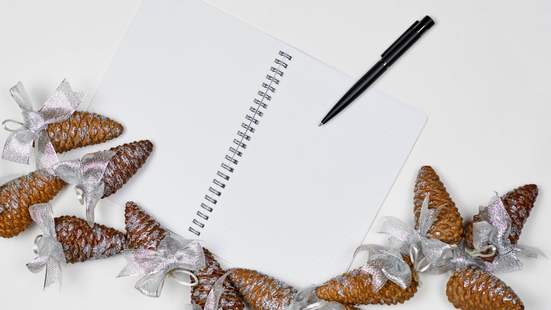 Еловые шишки на столе с блокнотом и ручкой