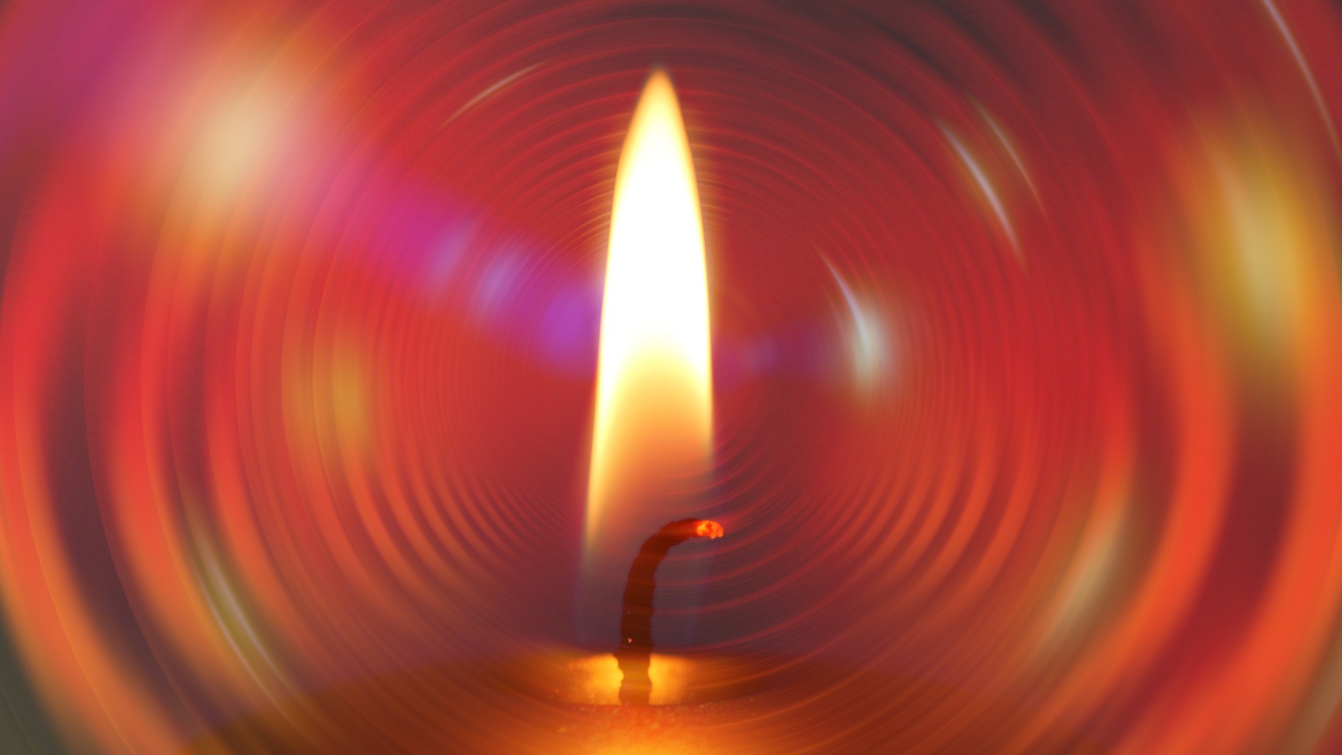 Огонь свечи на фоне красного круга 