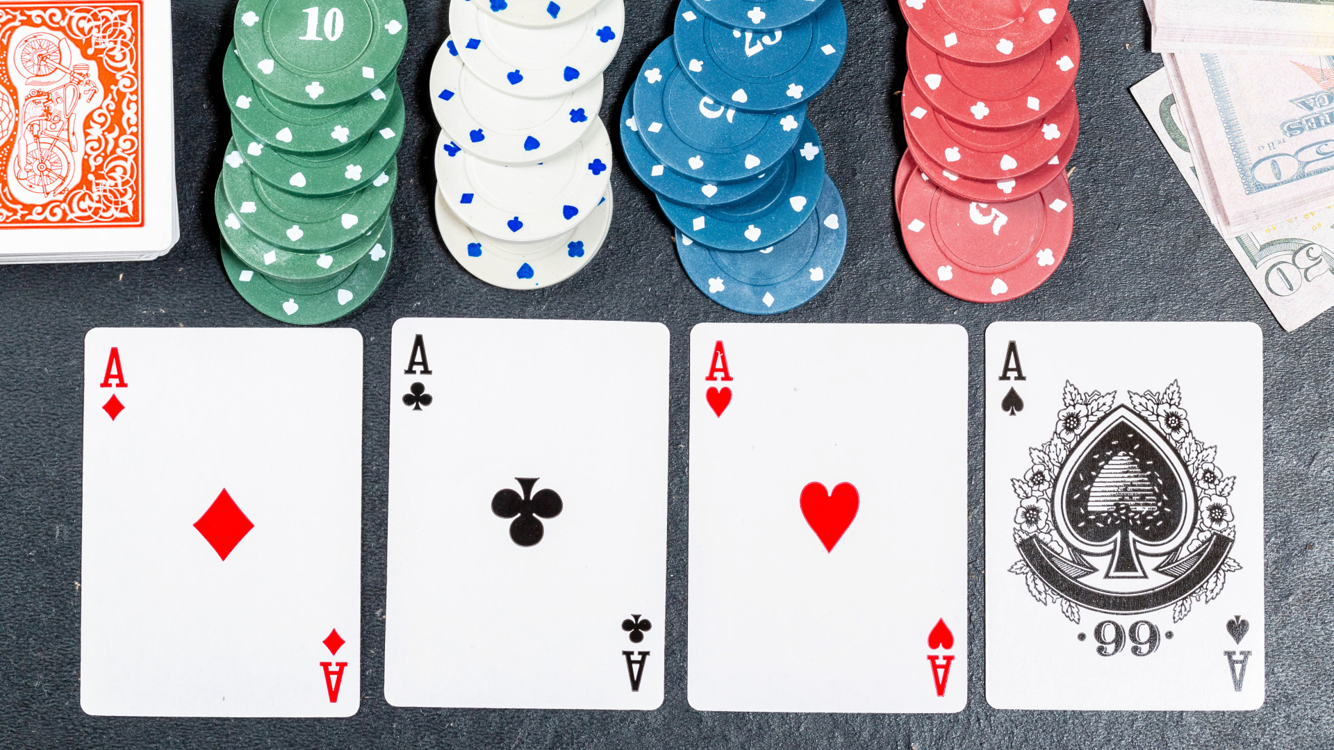 Четыре туза с фишками на сером столе