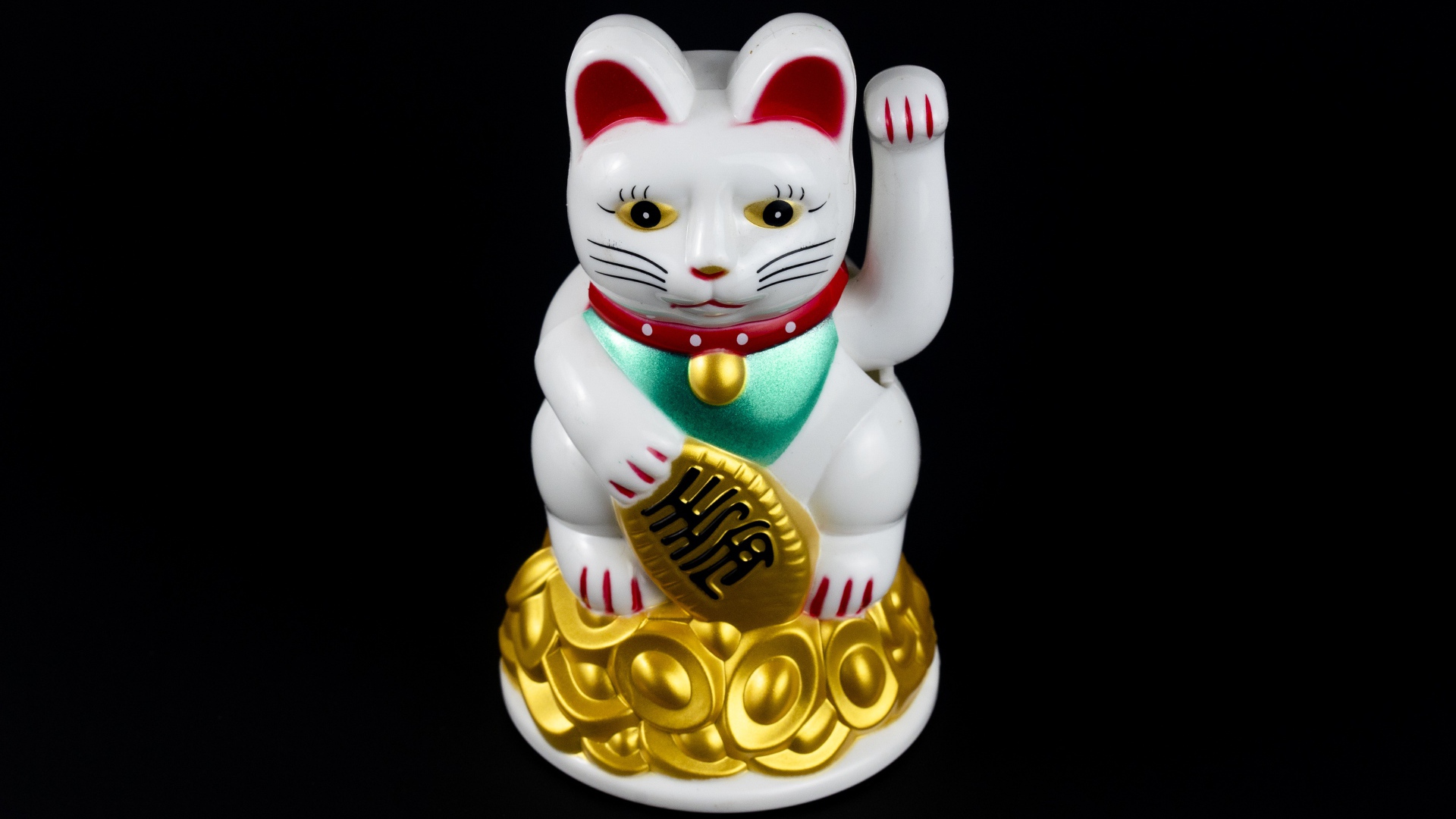 Японская фигурка манэки-нэко кошка на черном фоне