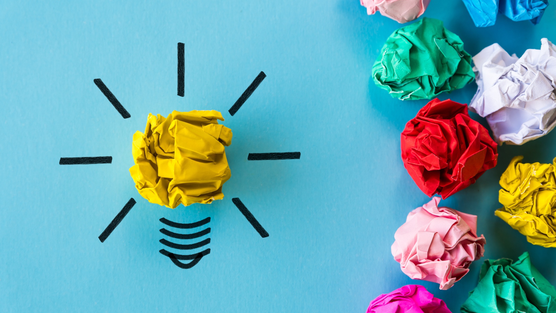 Комки разноцветной бумаги на голубом фоне 