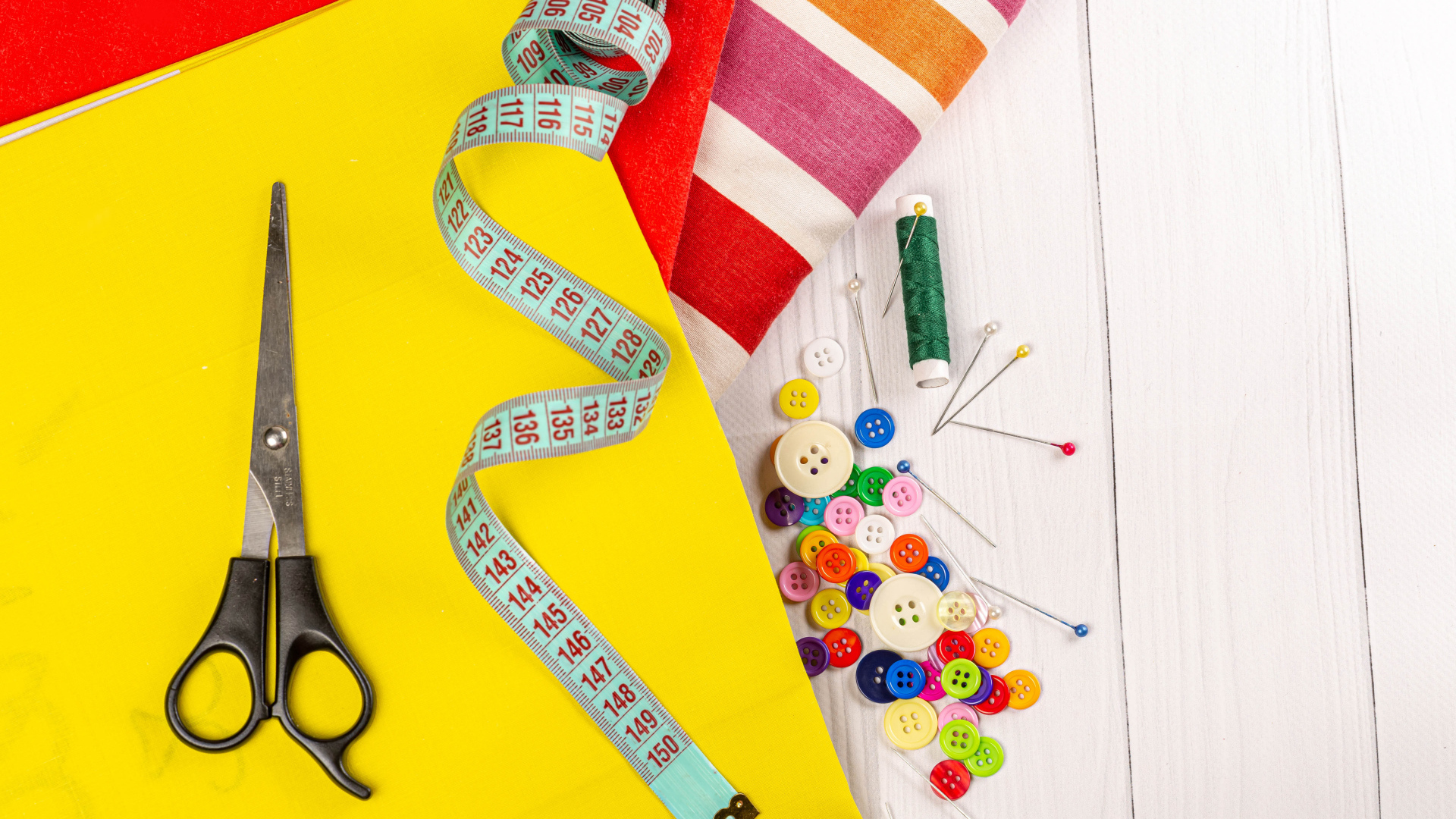 Разноцветная бумага и набор для шитья на столе 