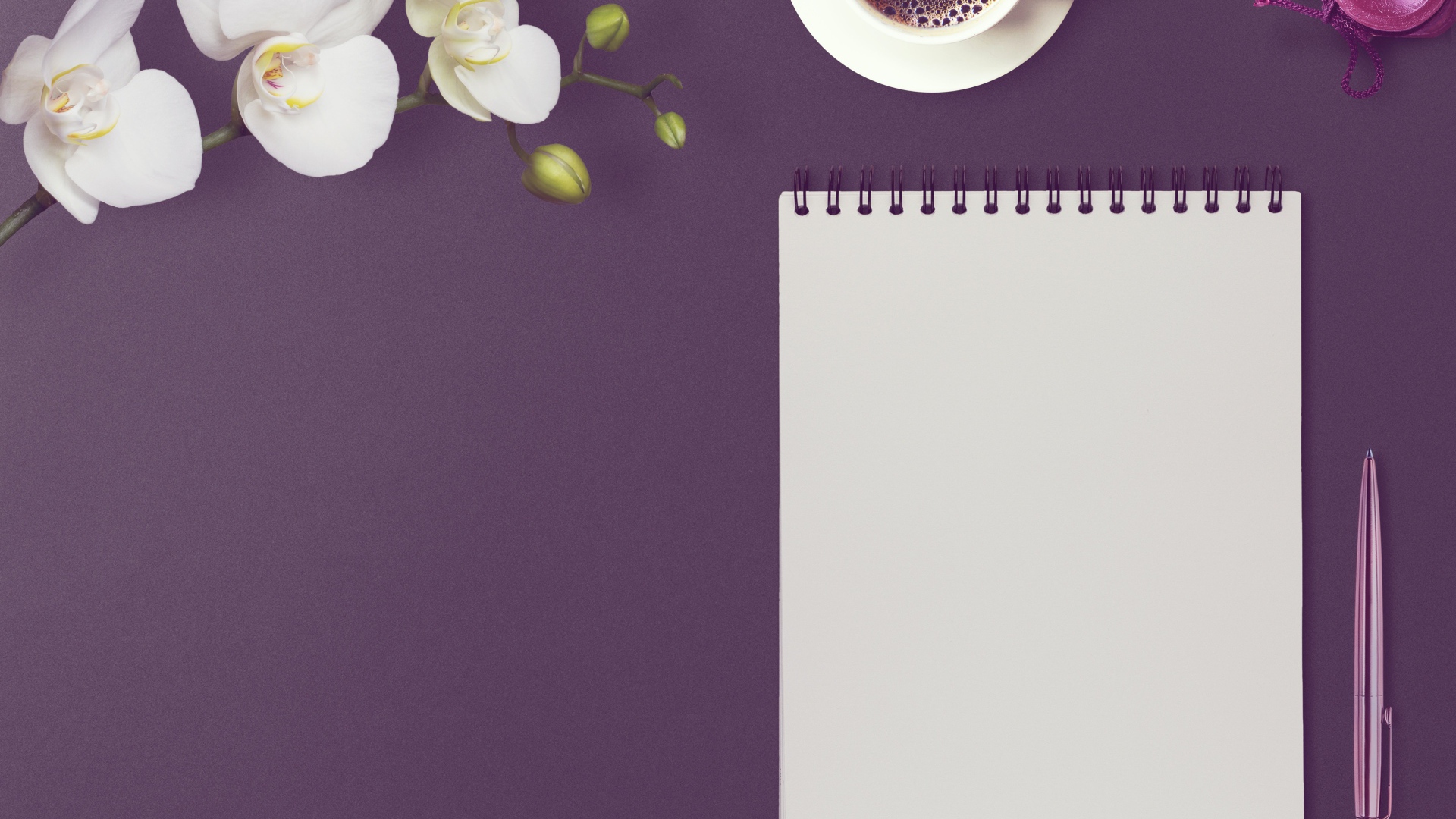 Блокнот с ручкой, цветами орхидеи и кофе на сиреневом фоне