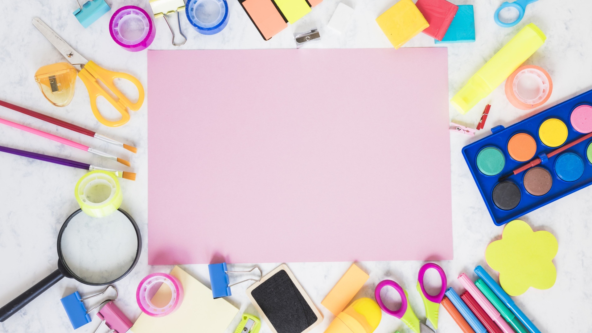 Лист бумаги, краски и канцелярские предметы на столе 