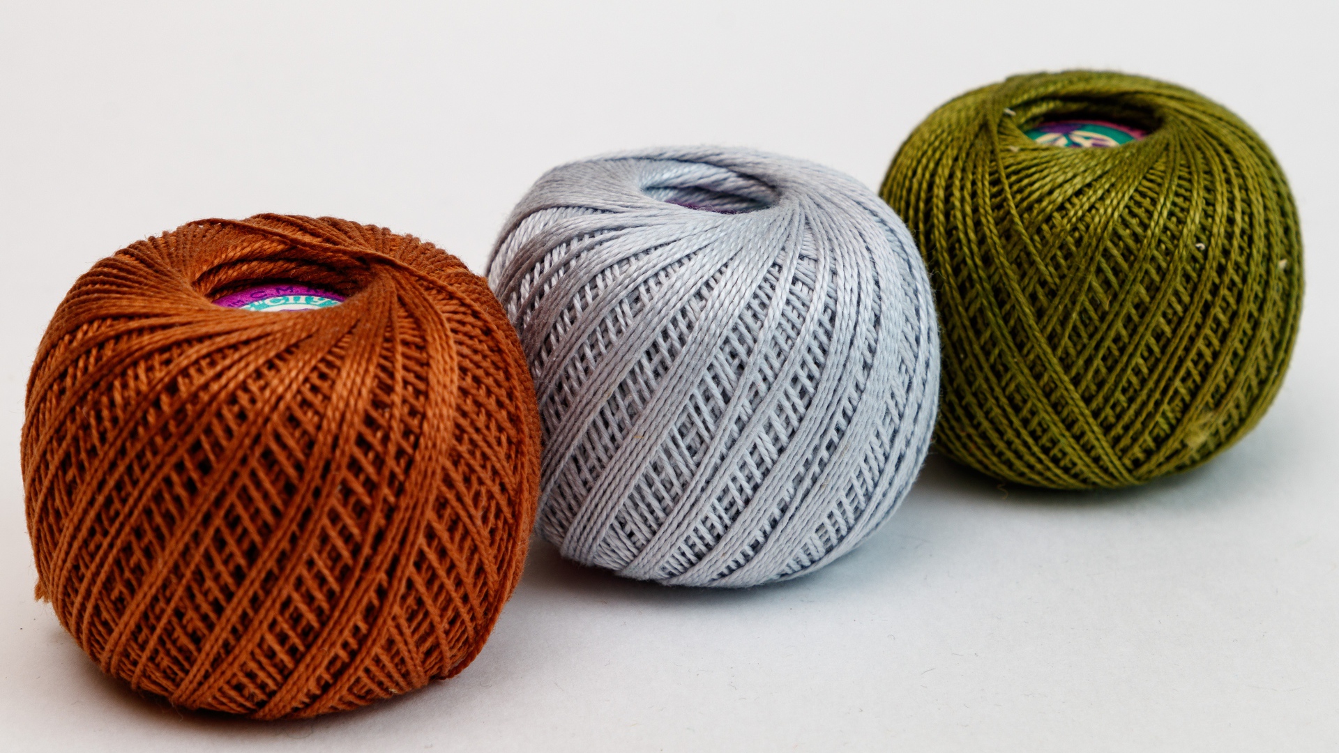 Три клубка пряжи на белом фоне 