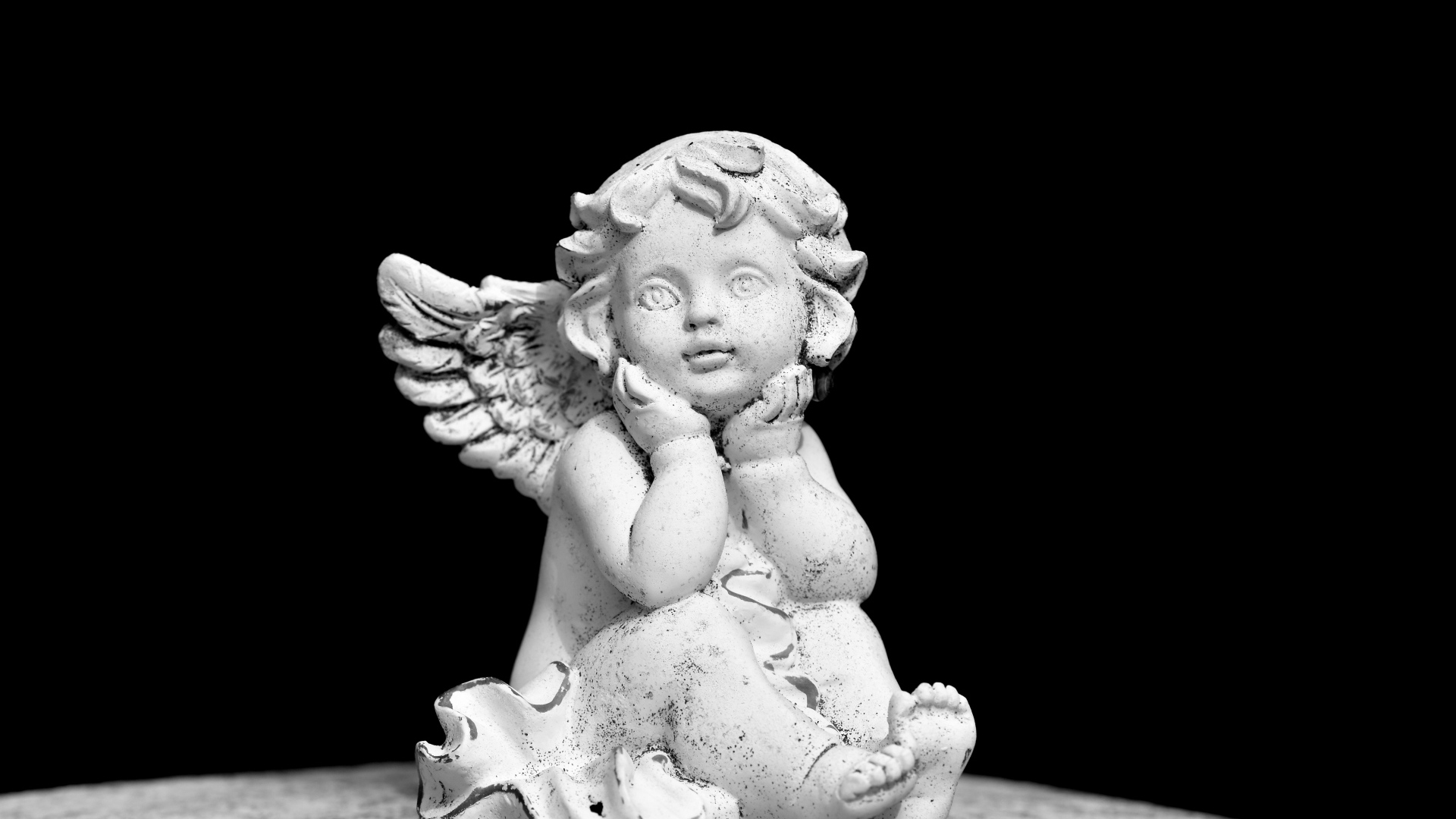Белая статуэтка ангел на черном фоне